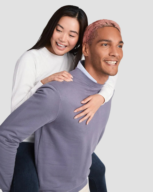 Two people posing together on a plain background