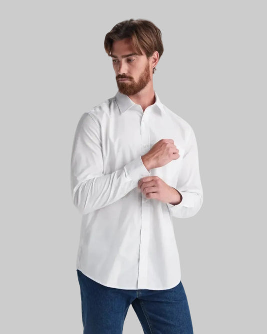 Man wearing a white shirt and blue jeans on a light gray background
