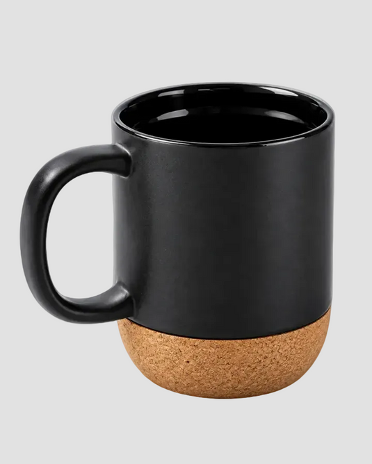 A matte black ceramic mug with a natural cork textured base, shown on a solid light gray background.