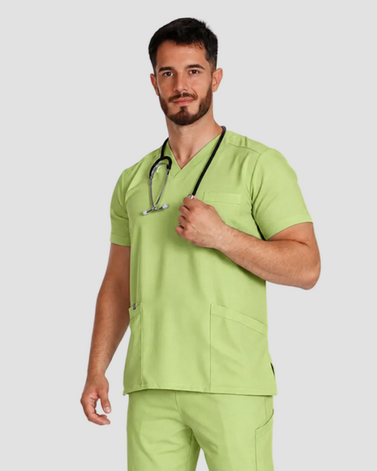 A man wearing a light green medical scrub set with a matching stethoscope, standing against a plain white studio background.