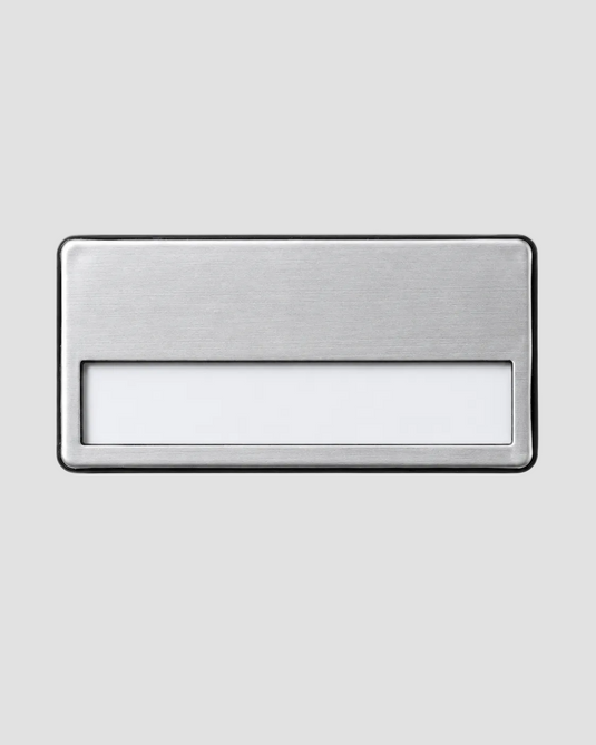 A minimalist rectangular metal wall-mounted light fixture with a brushed silver finish and a frosted white light panel, shown against a neutral light gray background.