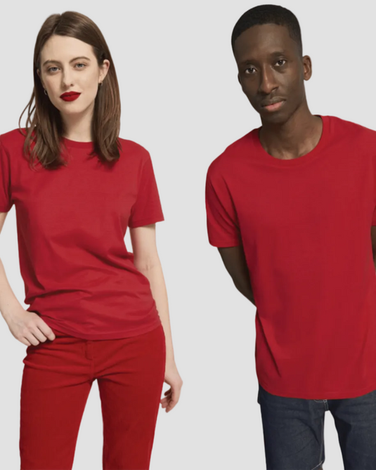 A woman in red pants and a man in a red T-shirt are posing. The T-shirt is suitable for both men and women, made of organic cotton, and is red in color.