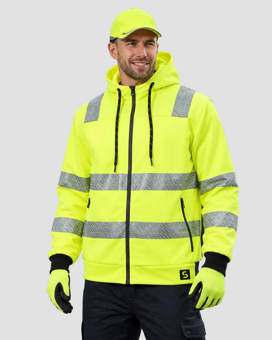 A man wearing a high-visibility neon yellow hooded jacket with reflective silver stripes, black gloves, and a matching cap, photographed against a plain light gray studio background.