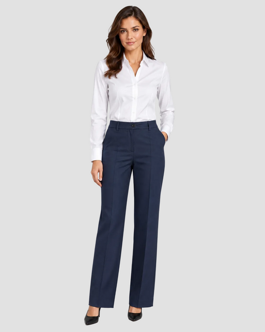 A woman modeling a white long-sleeve button-down shirt and navy blue straight-leg trousers, paired with black heels, against a solid gray studio background.